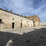 Usciamo dalla chiesetta e varchiamo ora il portone in legno della masseria che ci conduce in un vasto piazzale pavimentato con chianche...